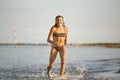 Water fun. the girl runs along the seashore.