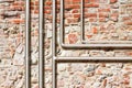 Water and gas pipeline in front of an old stone and brick wall Royalty Free Stock Photo