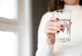 Water glass standing in womans hand