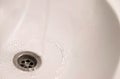 Water going down sink drain, above view. Royalty Free Stock Photo