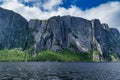Water, green foliage, cliff, blue sky with white clouds - Gros Morne National Park