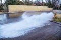 Water gushing out of a yellow fire hydrant across a residential road in an upscale neighborhood - selective focus