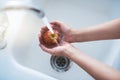 Water, hands and person cleaning apple, hygiene in kitchen with sustainability and disinfection, germs or bacteria Royalty Free Stock Photo
