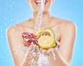 Water, hands and woman with fruit in studio on blue background for nutrition, wellness and health. Girl washing Royalty Free Stock Photo