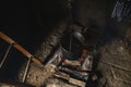 Water is heated in an old cauldron on fire, in an old rural room Royalty Free Stock Photo