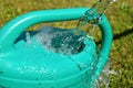 The water hose flows from the garden hose into the watering can. Wasteful wasting water. Royalty Free Stock Photo