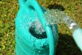 The water hose flows from the garden hose into the watering can. Wasteful wasting water. Royalty Free Stock Photo