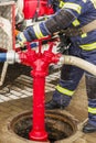 Water hydrant and firefighter turns taps Royalty Free Stock Photo