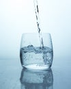 Water jet falling into glass with splashes and drops, air bubbles from a stream of water in glass. Many air bubbles in the water Royalty Free Stock Photo