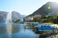 Water jet in Lake Lugano near the small town of Paradiso with mountains on the background and flare sun light, Lugano, Switzerland Royalty Free Stock Photo