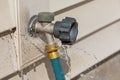 Water leaking from garden hose on outdoor spigot. Royalty Free Stock Photo