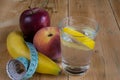 Water with lemon, fruits and measuring tape Royalty Free Stock Photo