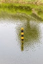 Water level indicator pole in natural lake showing the depth of Royalty Free Stock Photo