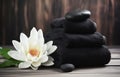 water lillies lotus flowers with stack towels and black spa stones on wooden background Royalty Free Stock Photo