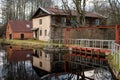 Water mill on the shore of lake and its reflection on the surface of the water Royalty Free Stock Photo
