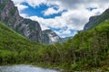 Water with mountain in background; blue sky with white clouds - Gros Morne National Park