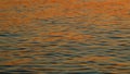 Water In Ocean With Sunset Reflected On Waves. View Of Calm Waves. Abstract Nature Background. Slow motion.