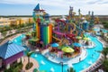 water park with towering slides and interactive water features, surrounded by vibrant and colorful atmosphere