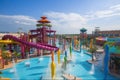 water park with towering slides and interactive water features, surrounded by vibrant and colorful atmosphere