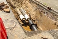 Water pipes in ground pit trench ditch during plumbing under construction repairing. Repair of a water supply or gas pipeline Royalty Free Stock Photo