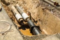 Water pipes in ground pit trench ditch during plumbing under construction repairing. Repair of a water supply or gas pipeline Royalty Free Stock Photo