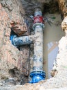 Water pipes in ground pit trench ditch during plumbing under construction repairing Royalty Free Stock Photo