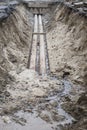 Water pipes in ground during plumbing construction site pit trench ditch Royalty Free Stock Photo