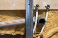 Water pipes made of polypropylene in the wall, plumbing in the house. Installation of sewer pipes in a bathroom of an apartment in