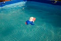 Water pistol swimming in pool, blue transparent water in sun rays. Outdoors summer activities for children Royalty Free Stock Photo