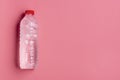 Water plastic bottle on pink background. Cold bottle of water