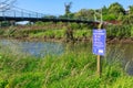 A water pollution warning sign by a New Zealand stream