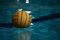 Yellow water polo ball in a swimming pool on blue water background