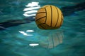 Yellow water polo ball in a swimming pool on blue water background