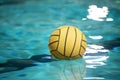 Yellow water polo ball in a swimming pool on blue water background