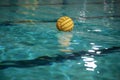 Yellow water polo ball in a swimming pool on blue water background