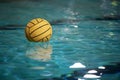 Yellow water polo ball in a swimming pool on blue water background Royalty Free Stock Photo