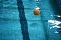 Yellow water polo ball in a swimming pool on blue water background Royalty Free Stock Photo