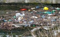 Water polution. Plastic and other residues thrown into the water. A large amount of trash polluting our waters. The Impact of Royalty Free Stock Photo