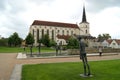 Water pool with modern open air sculptures, Church of the Exaltation of the Holy Cross in the background, Litomysl, Czechia