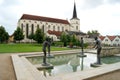 Water pool with modern open air sculptures, Church of the Exaltation of the Holy Cross in the background, Litomysl, Czechia