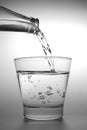 Water poured from the bottle to the small glass Royalty Free Stock Photo