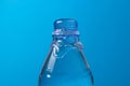 Water is poured out and a plastic bottle on a blue background. Royalty Free Stock Photo