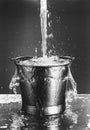 Black and white photo of Water pouring into a bucket Royalty Free Stock Photo