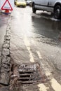 Water Pouring Down Drain On Flooded Road