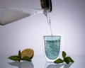 water pouring into glass from glass decanteron transparent light blue background, drink clean water, concept Royalty Free Stock Photo