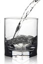 Water pouring into glass with its reflection, closeup view, isolated on white Royalty Free Stock Photo