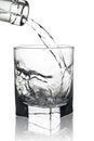 Water pouring into glass with its reflection, closeup view, isolated on white Royalty Free Stock Photo