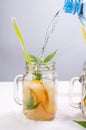 Water pouring into jar with orange and mint Royalty Free Stock Photo