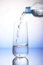 Water pouring from plastic bottle into drinking glass Royalty Free Stock Photo