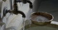 Water is pouring from two metal tap on marble wall and washbowl in traditional hammam